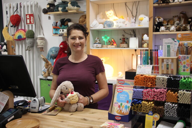 Inhaberin des Spielschlau Jena hinter der Kasse mit Kuscheltier (Hase) und Beratung