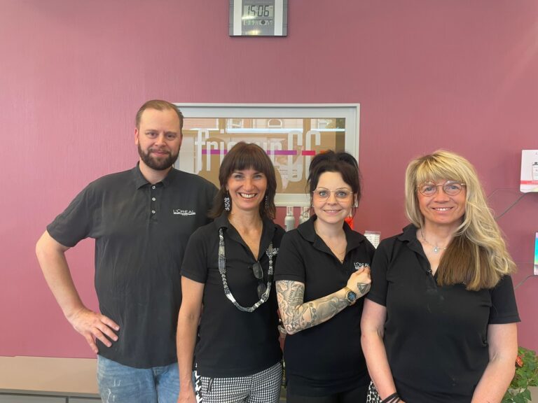 Das vierköpfige Friseur-Team von Friseur CC in Jena steht lächelnd in einheitlicher schwarzer Arbeitskleidung zusammen.