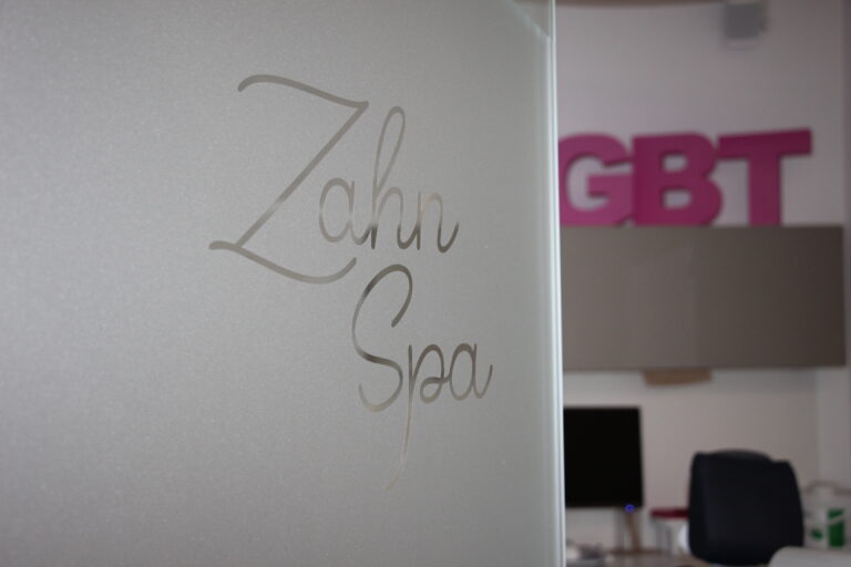 Schriftzug "Zahn Spa" in eleganter Schreibschrift auf mattiertem Glas in der Praxis.