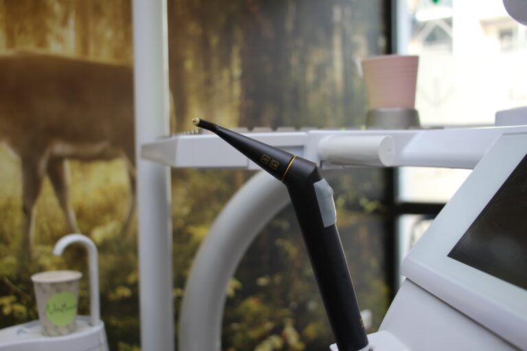 Nahaufnahme eines schwarzen, modernen Handstücks (zahnmedizinisches Instrument) an der Behandlungseinheit.