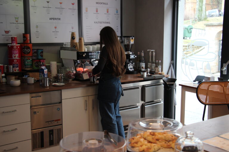 Eine Barista bei der Kaffeezubereitung an der Espressomaschine im Café Harmony.