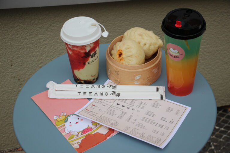 Getränke und gedämpfte Baos vom Restaurant Mrs. Bao in Jena auf einem Tisch, daneben eine Speisekarte und Stäbchen.