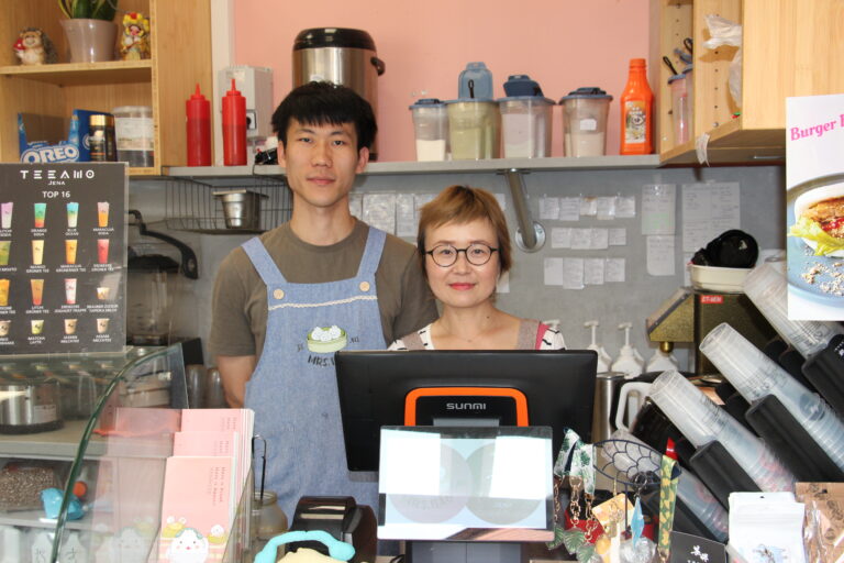 Zwei Personen stehen hinter der Theke im Restaurant Mrs. Bao in Jena, mit Getränkekarte und Kassentheke im Vordergrund.