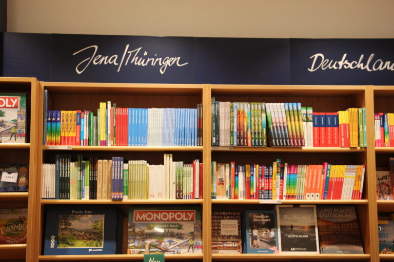 Bücherregale in der Thalia Buchhandlung unter den blauen Rubrik-Schildern "Jena/Thüringen" und "Deutschland".