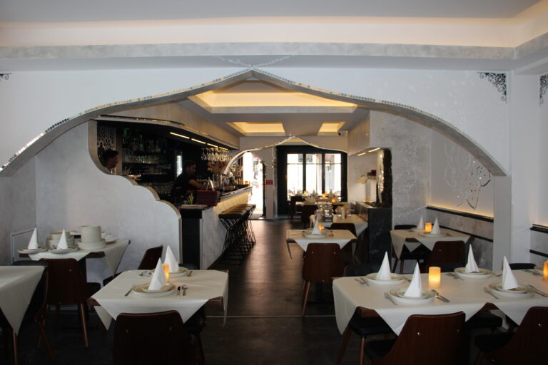 Weitwinkel-Blick auf den Gastraum des Naan n Curry mit geschmackvollem Arch-Design und Blick zur Bar.