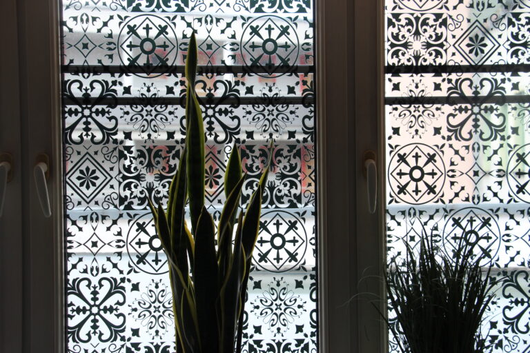 Fenster im Naan n Curry mit orientalischem Dekor-Muster und Pflanzen im Vordergrund.