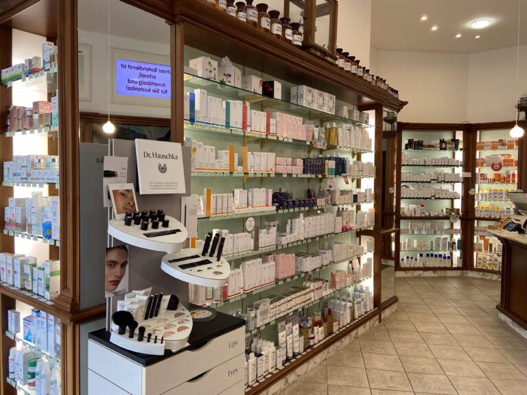 Elegante Holzregale präsentieren ein umfangreiches Sortiment an Pflegeprodukten, im Vordergrund ein Aufsteller der Naturkosmetik-Marke Dr. Hauschka.